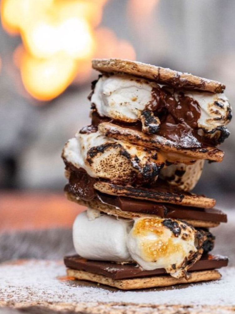 stack of s'mores by a fire