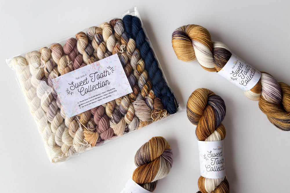 speckled semisolid hand dyed white tan purple brown blue yarn and set