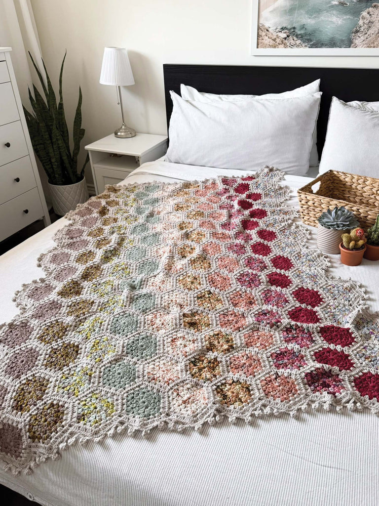 blanket on a bed, made out of semisolid speckled hand dyed desert colors of dk yarn