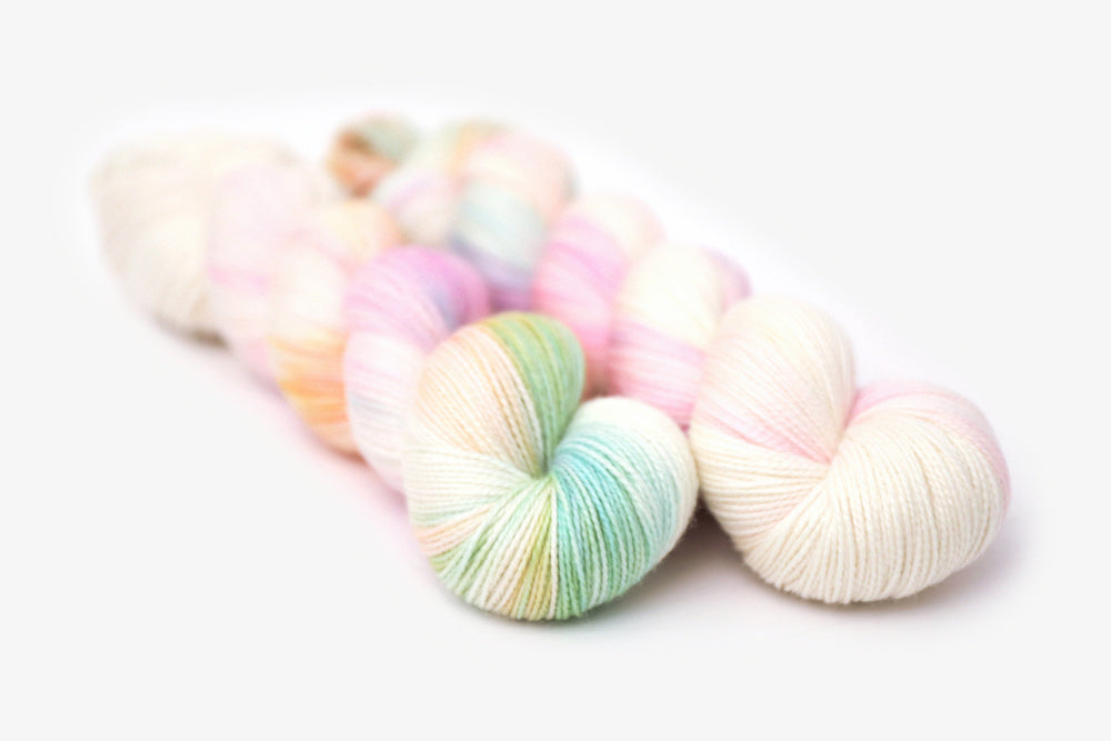 tonal hand dyed white pink plum peach green blue merino sock yarn