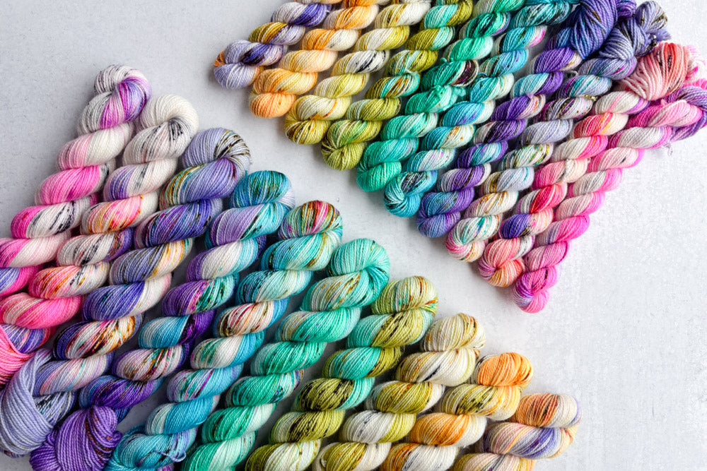 speckled hand dyed white orange pink purple teal green yarn