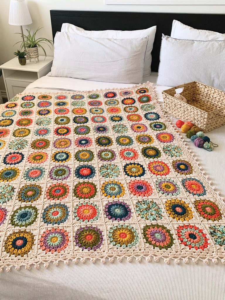 blanket on a bed, made out of semisolid speckled hand dyed desert colors of dk yarn