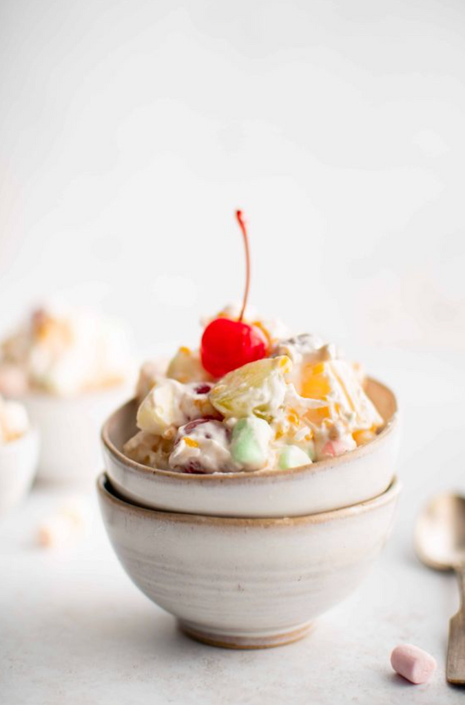 ambrosia fruit salad with cherry in a ceramic bowl