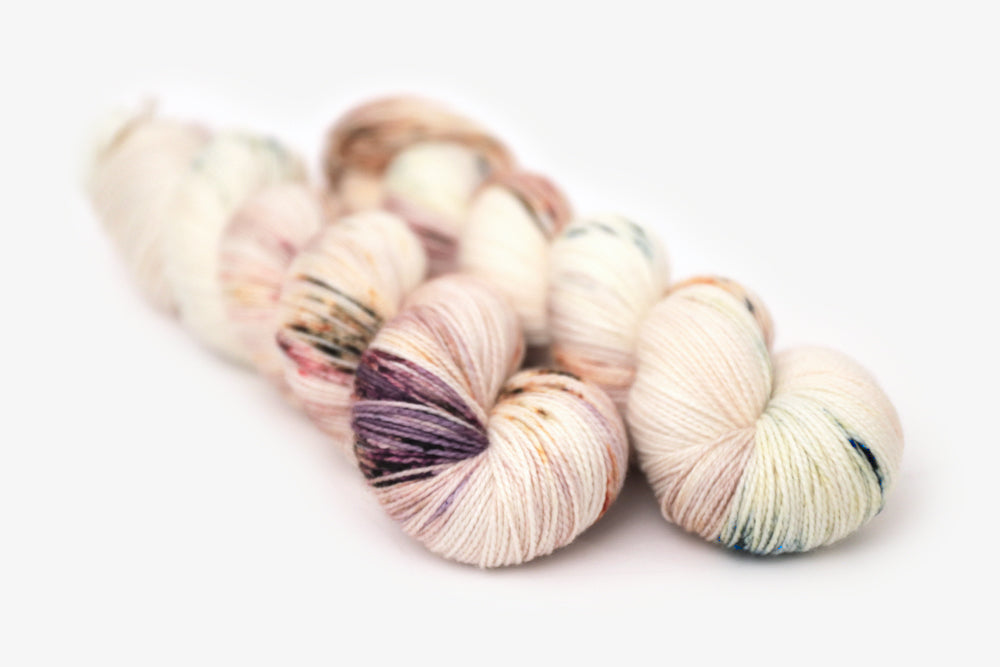 speckled hand dyed white pink mauve merino sock yarn